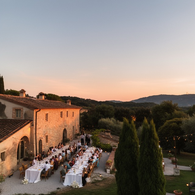 Hochzeitslocation in der Toskana bei Sonnenuntergang, mit langer gedeckter Tafel im Garten